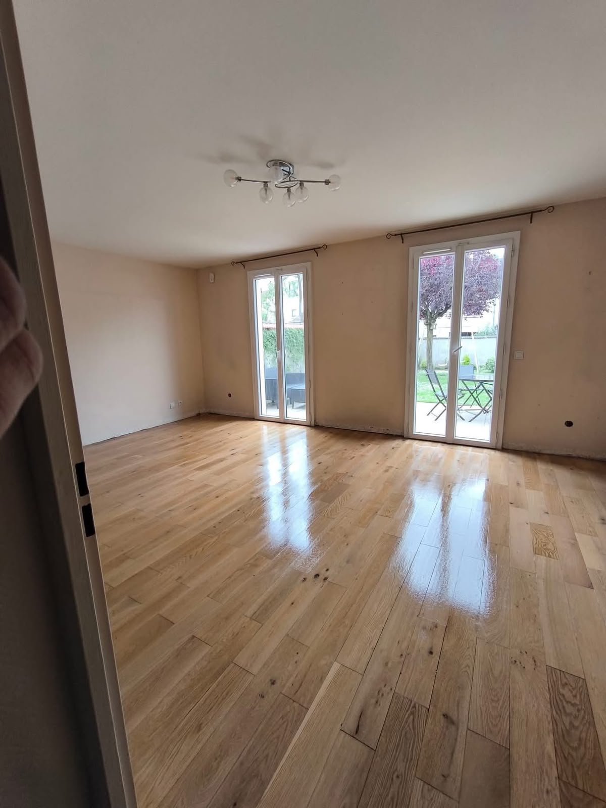 Salon rénové avec parquet et baie vitrée